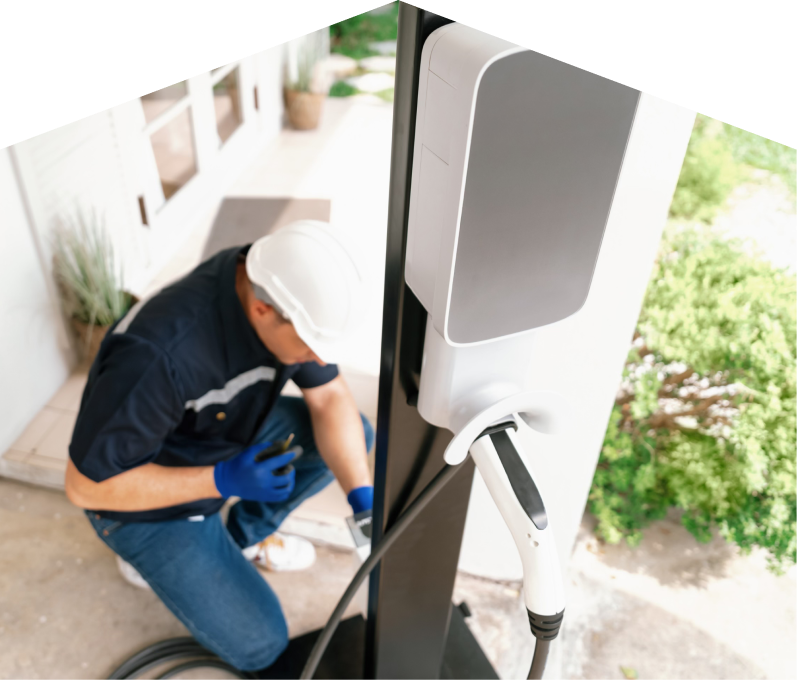 Home service electrician from Francis installing an EV charger fixed to a vertical post near a residential entryway. Home service electrician from Francis installing an EV charger fixed to a vertical post near a residential entryway.